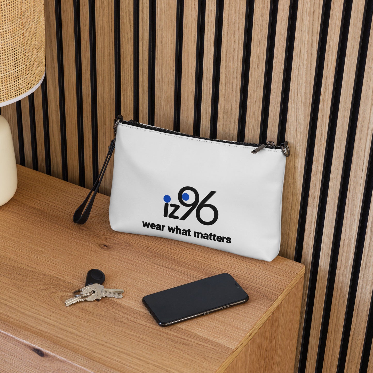 White pouch with 'iz96 wear what matters' logo on a wooden surface.