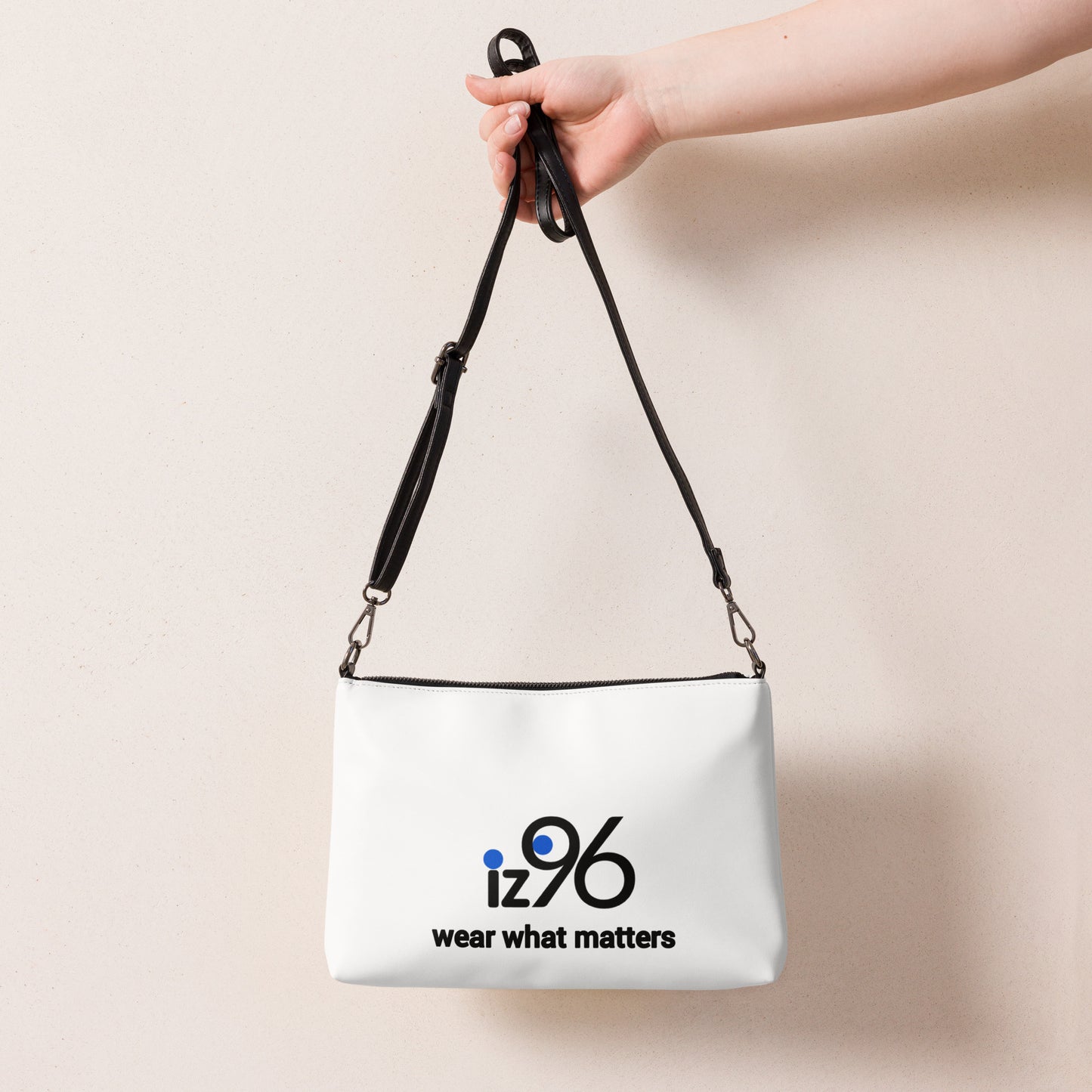 White bag with 'iz96' logo held by a hand against a beige background