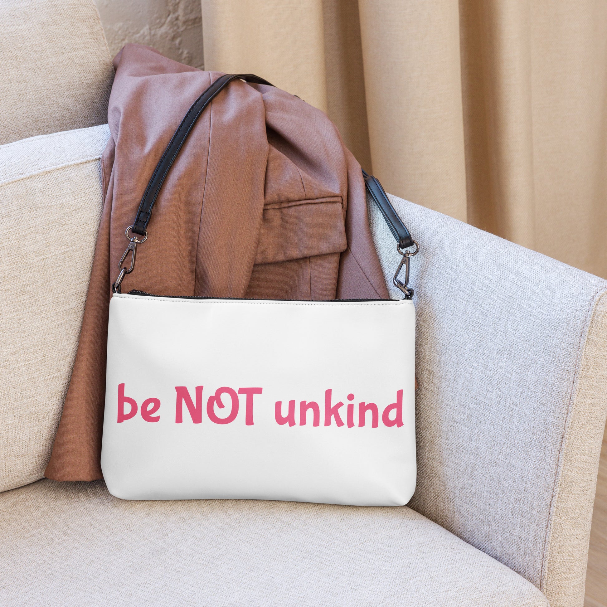 White bag with 'be NOT unkind' text on a beige couch