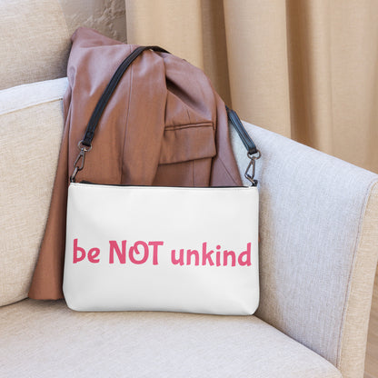 White bag with 'be NOT unkind' text on a beige couch