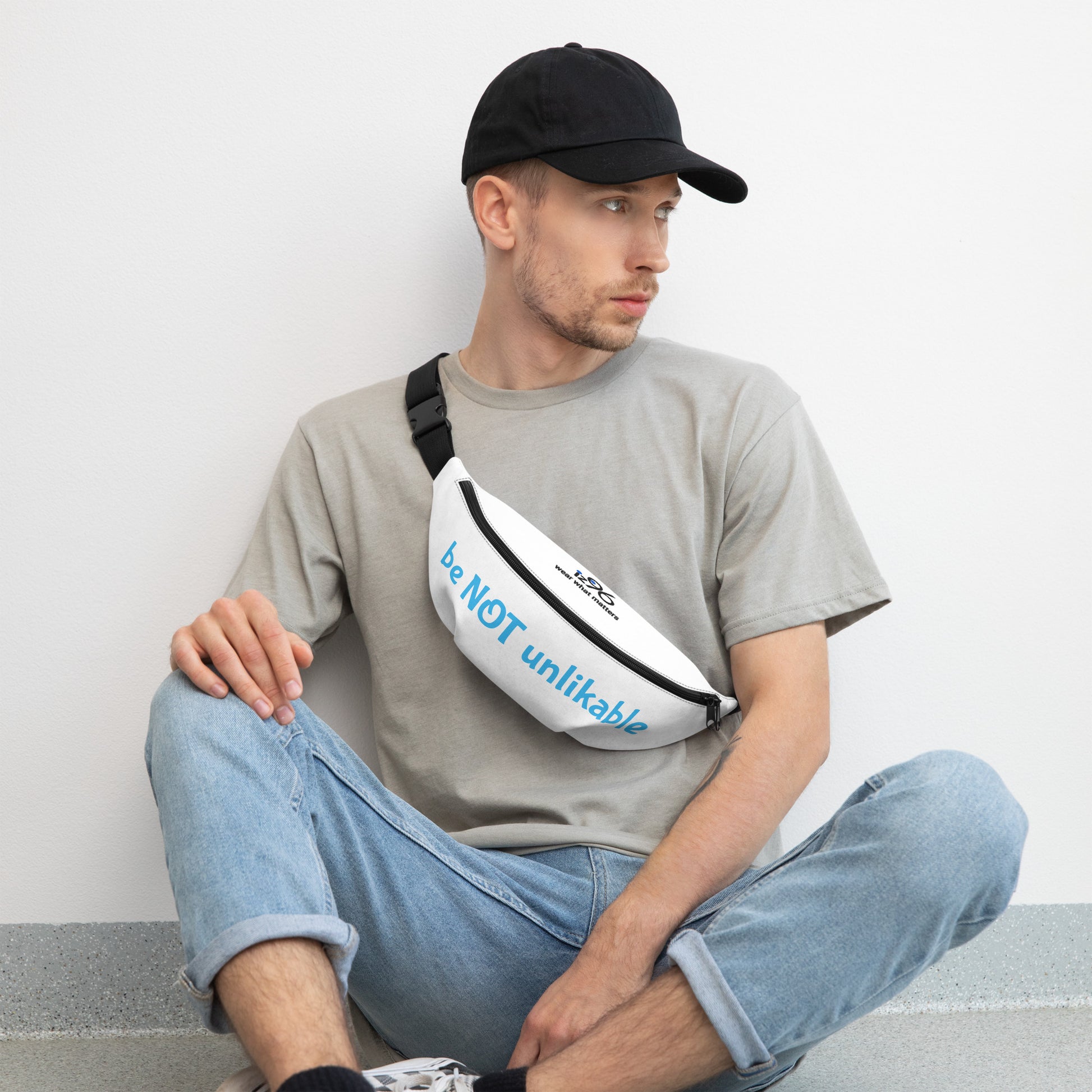 Man sitting with a white fanny pack featuring black patterns on a light gray background