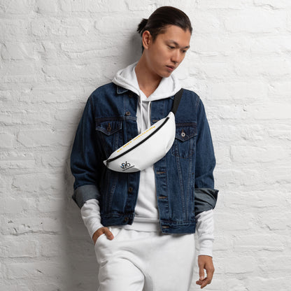 Person wearing a denim jacket and white hoodie with a white bag, standing against a textured white wall.