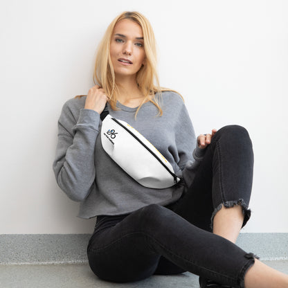 Woman sitting on the floor with a white fanny pack.