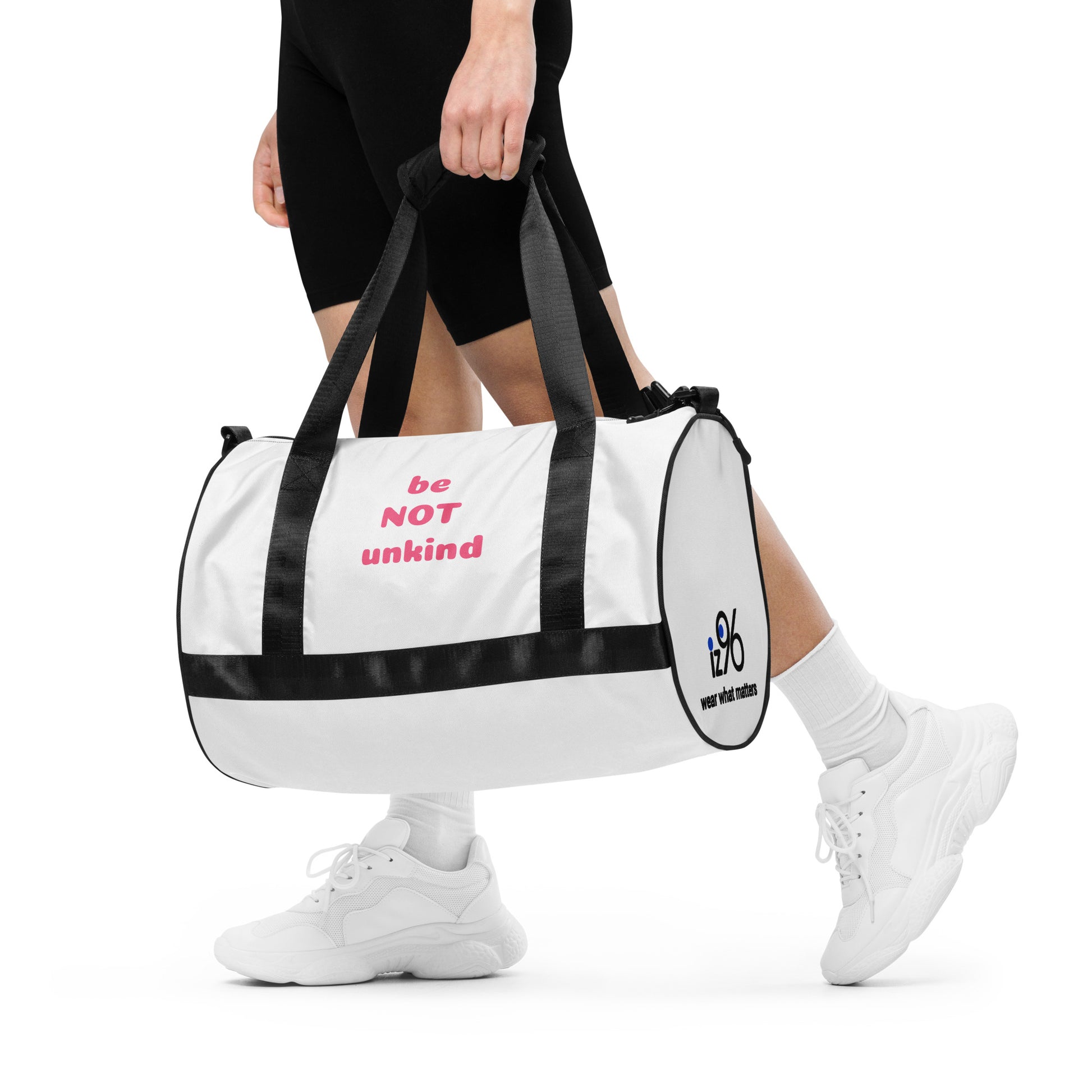 Person holding a white duffel bag with 'be not unkind' text on a white background