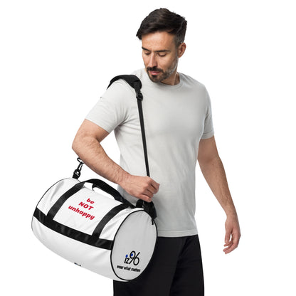 Man holding a white duffel bag with 'be not unhappy' on a white background