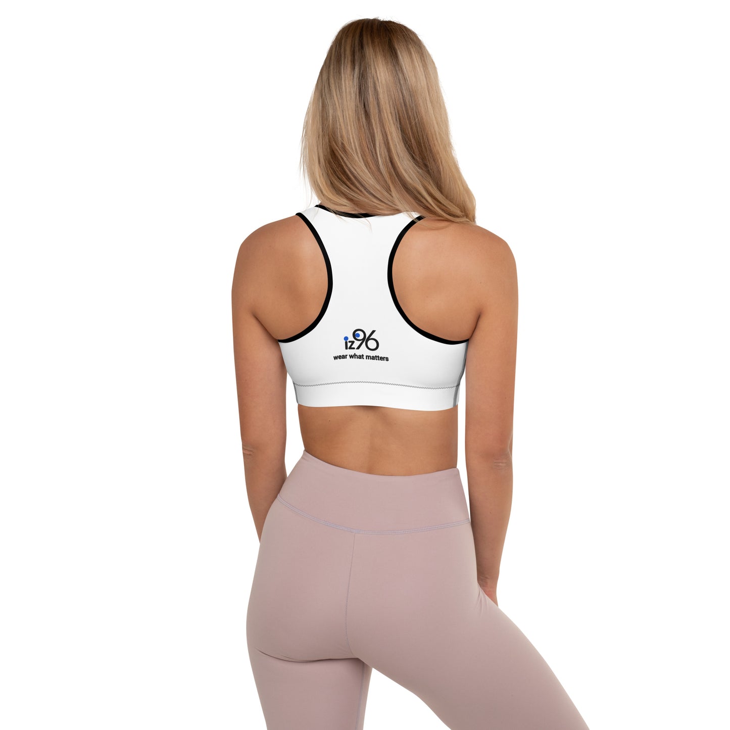 Person wearing a white with black sports bra with a logo on the back, standing against a white background