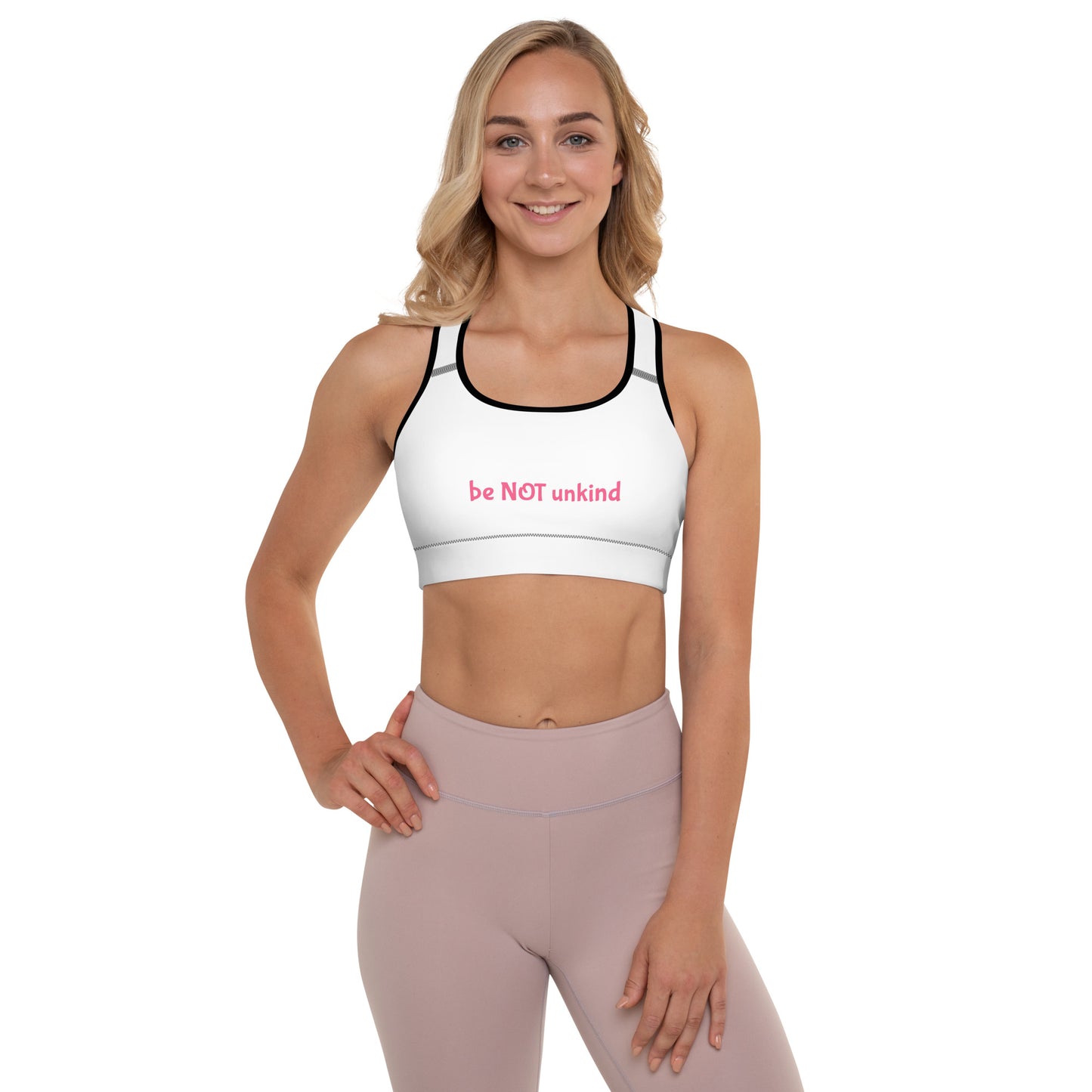 Woman wearing a white sports bra and pink leggings on a white background