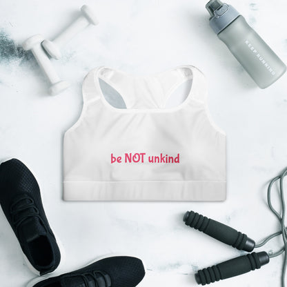 White sports bra with black sneakers, gray water bottle, and jump rope on a light surface