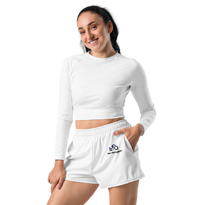 Woman wearing a white long-sleeve crop top and shorts on a white background