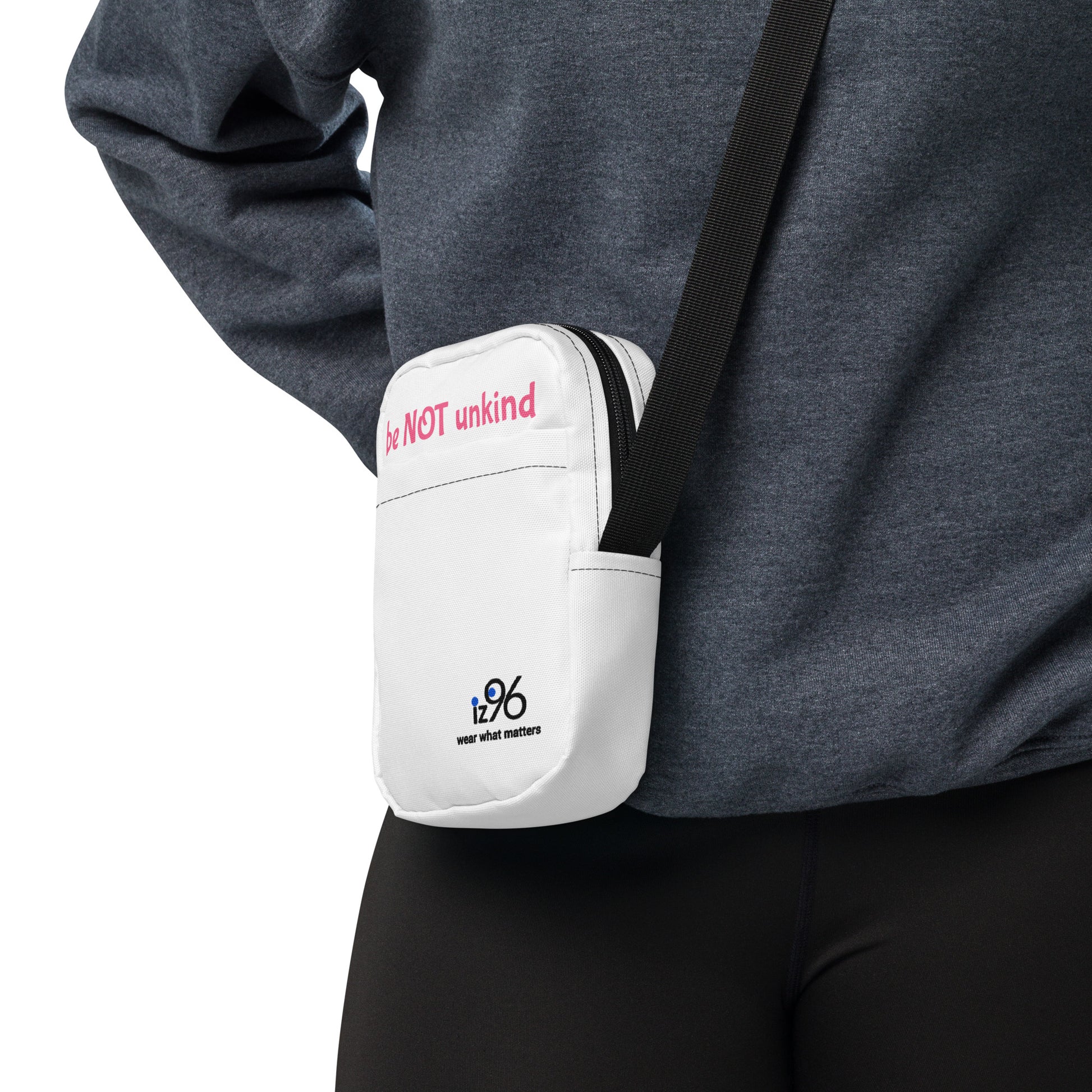 White crossbody bag with a visible brand logo worn by a person on a white background