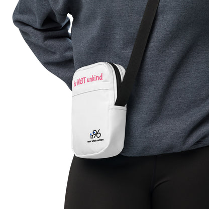 White crossbody bag with a visible brand logo worn by a person on a white background
