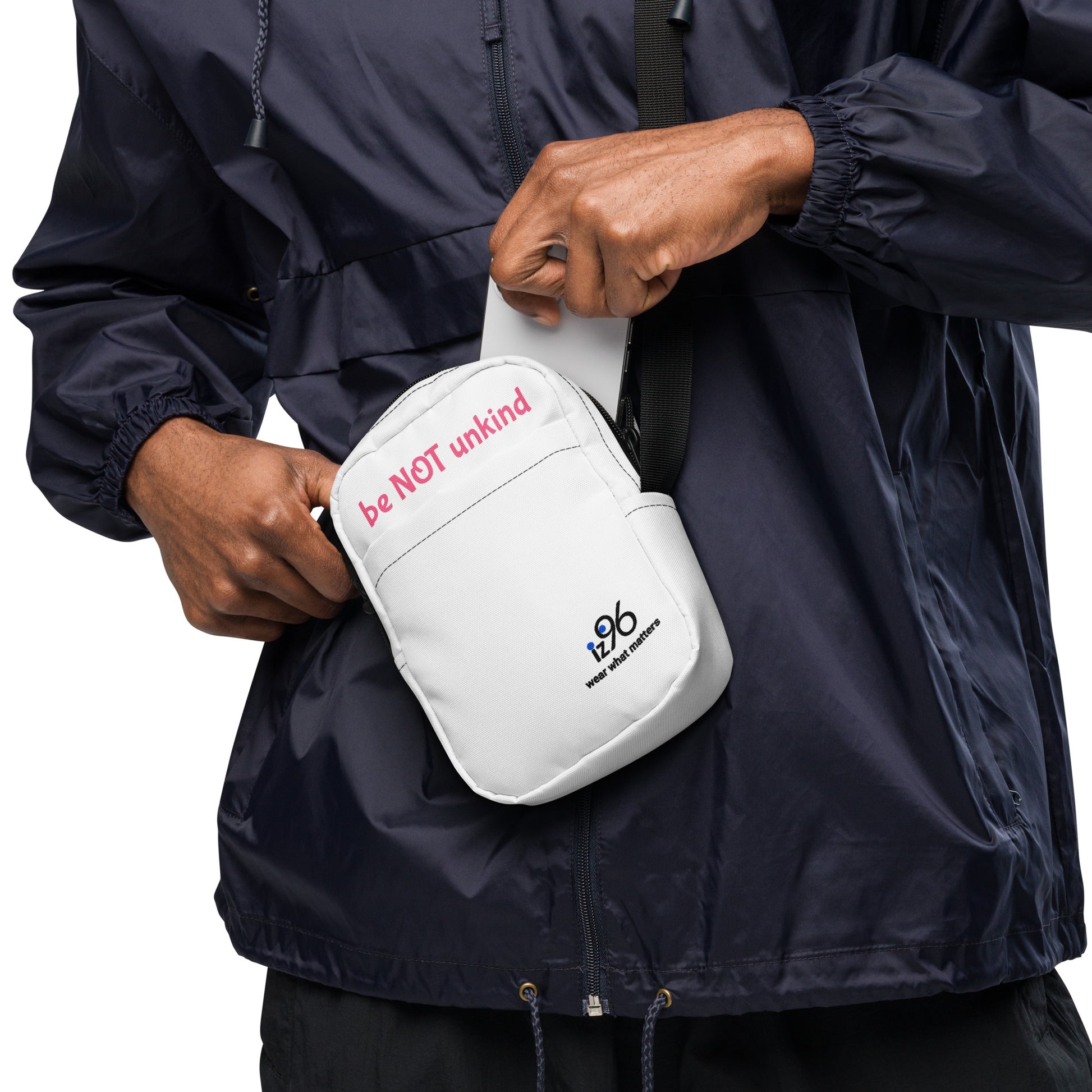 Person wearing a navy raincoat holding a white bag with text and a logo.