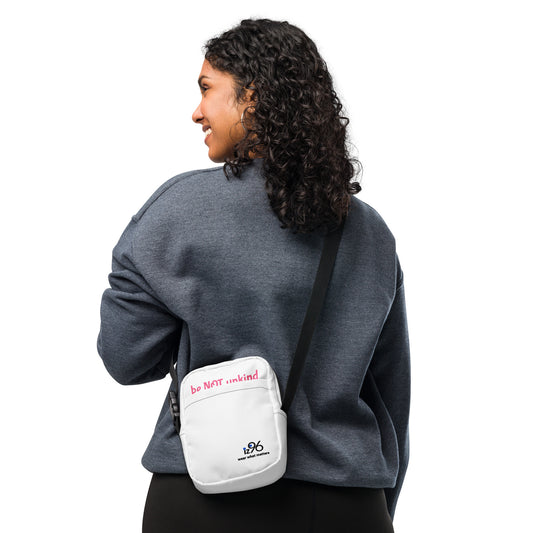 Person wearing a gray sweatshirt with a white crossbody bag featuring text and a logo.