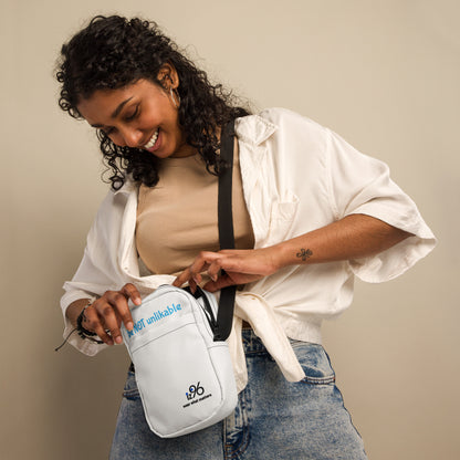 Woman holding a white bag with text and a logo on a beige background