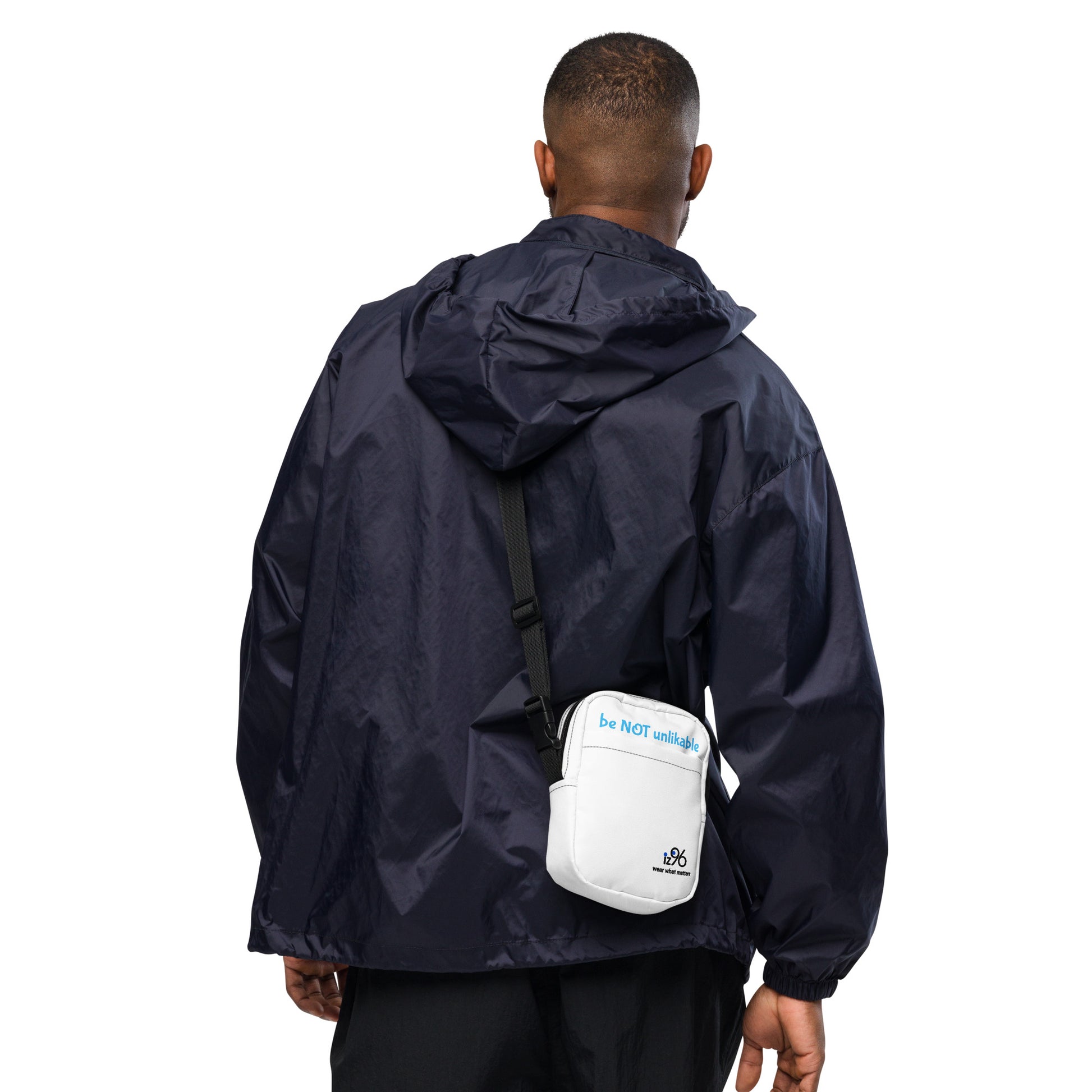 Person wearing a navy raincoat with a white bag on a white background