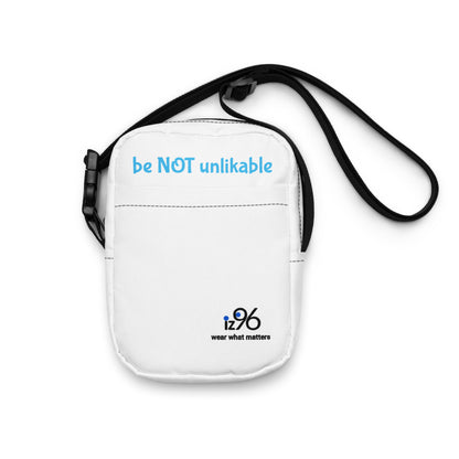 White crossbody bag with 'be NOT unlikable' text and 12:96 logo on a white background