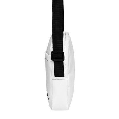 White crossbody bag with a black strap on a white background