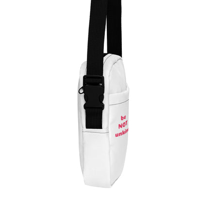 Pink and white crossbody bag with black strap on a white background