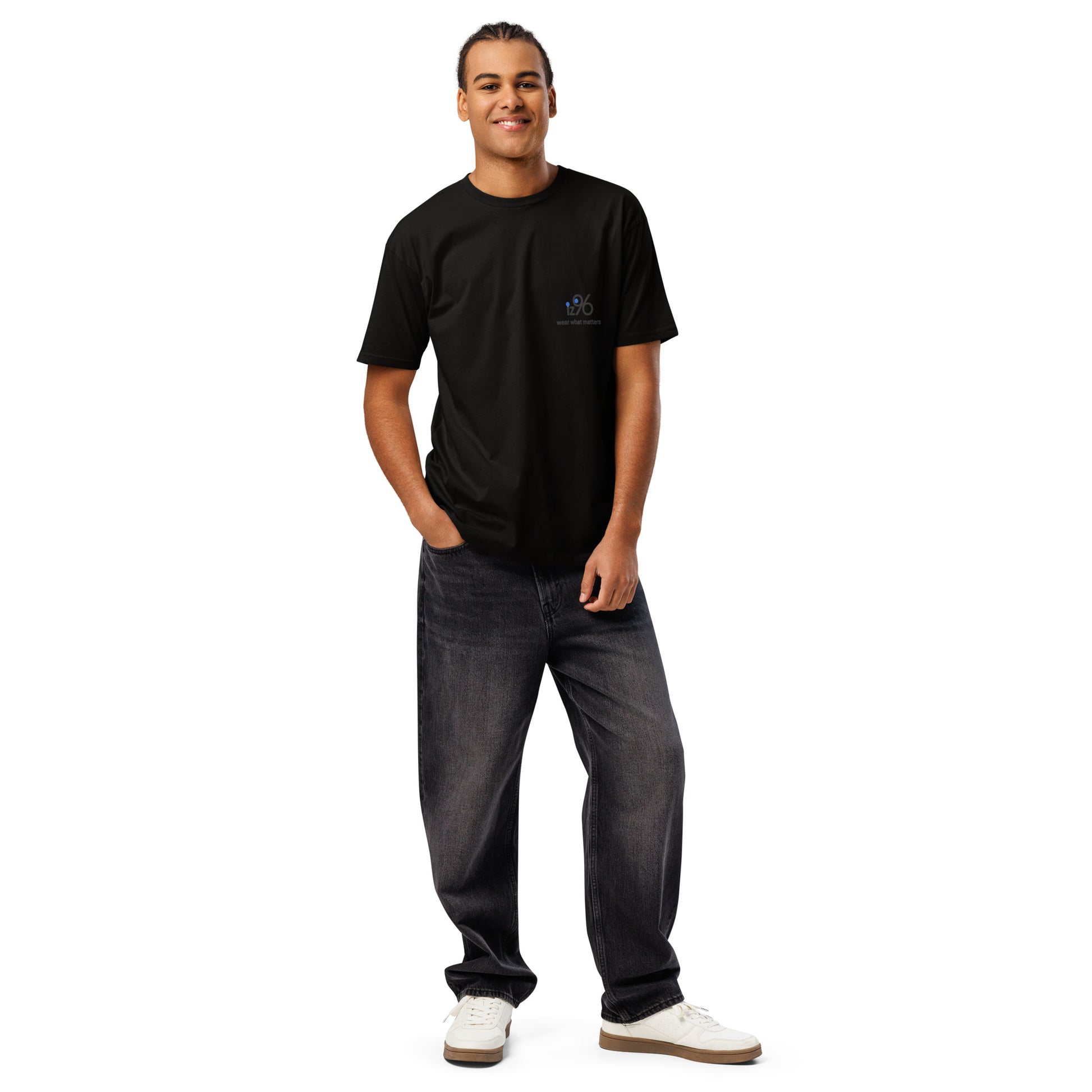Man wearing a black t-shirt with a logo and dark jeans on a white background