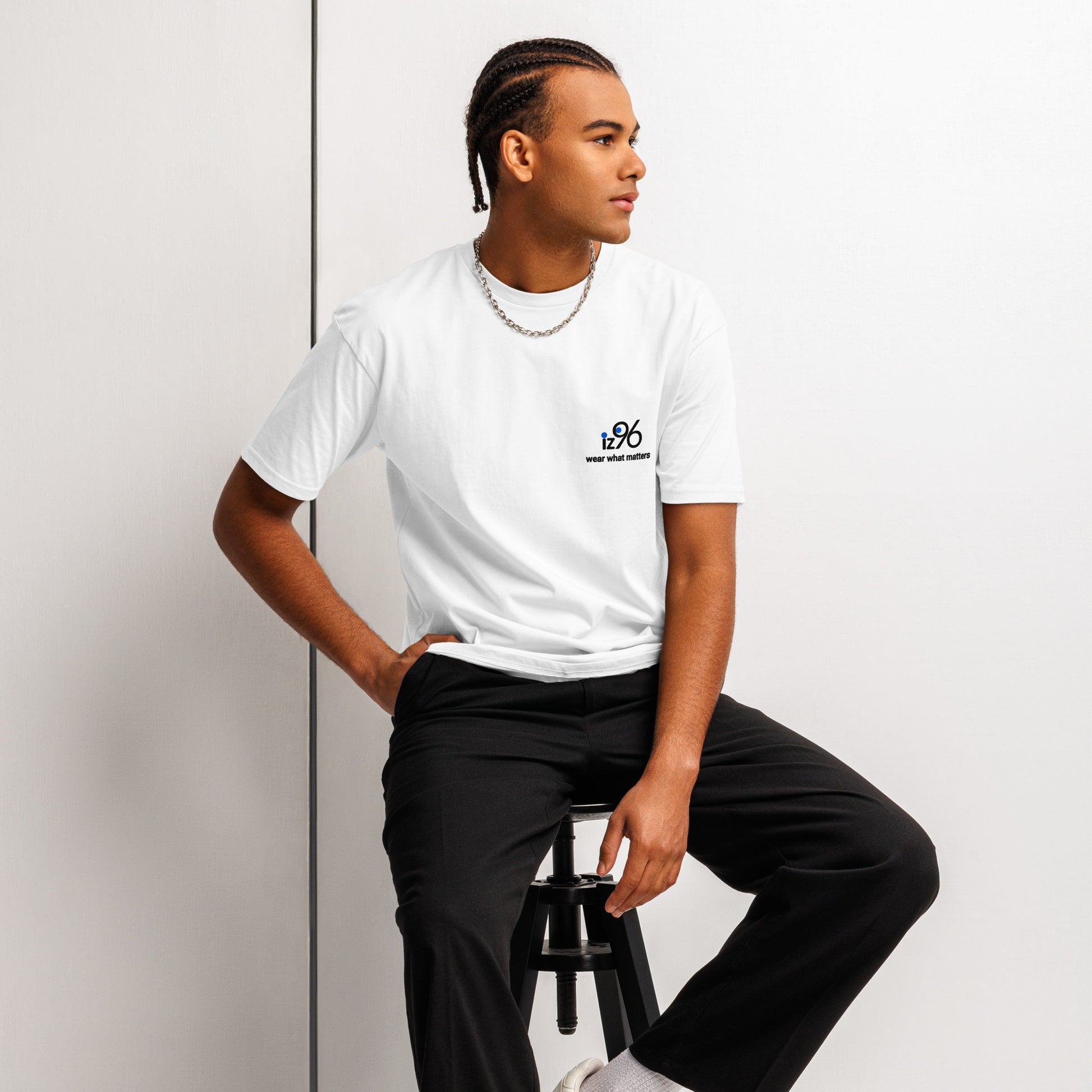 Person wearing a white t-shirt with 'Just Breathe' text, sitting on a stool against a plain background