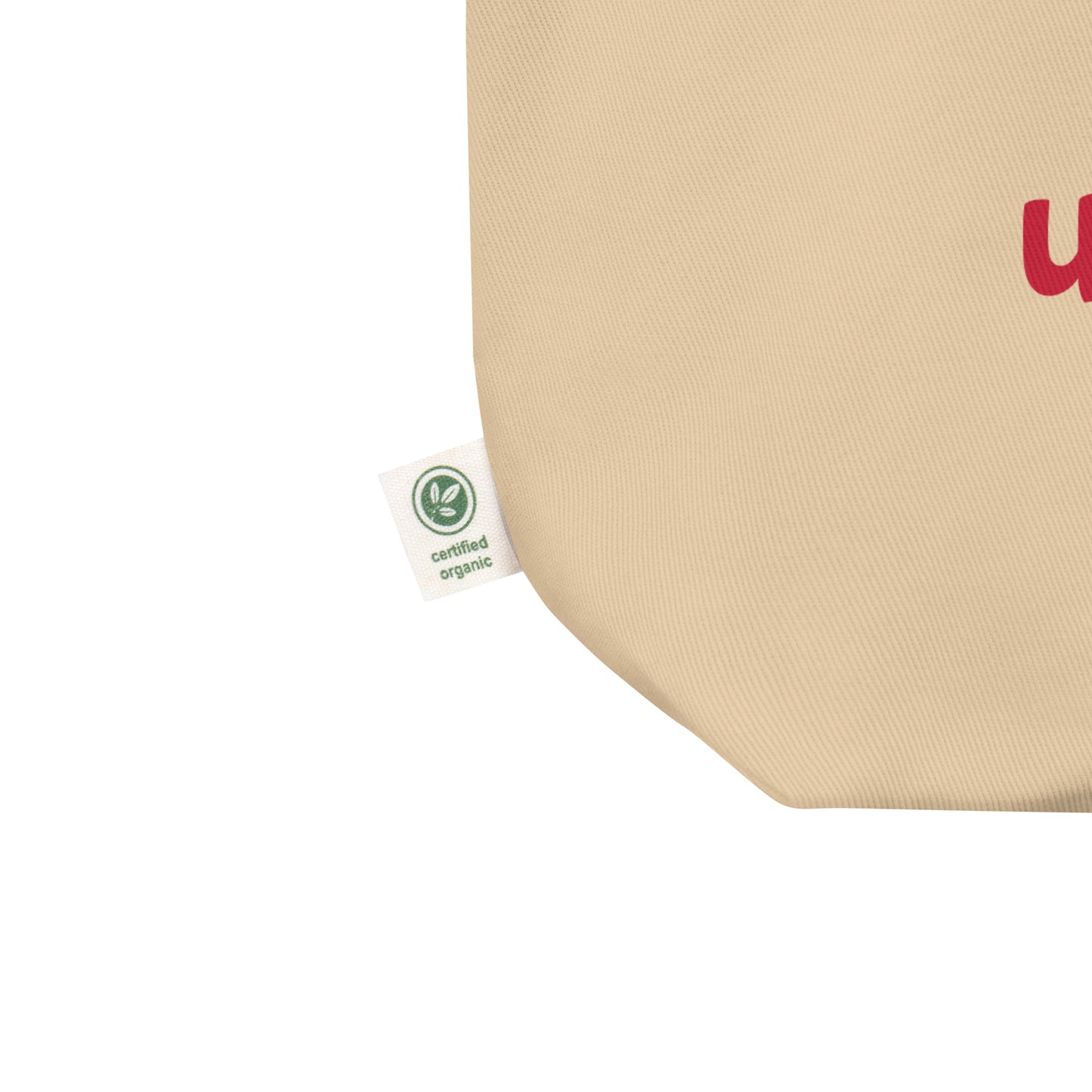 Beige tote bag with a logo worn by a person on a white background