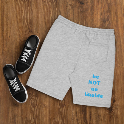 Gray shorts with text and black sneakers on a wooden surface
