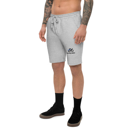 Person wearing gray shorts with a logo on a white background