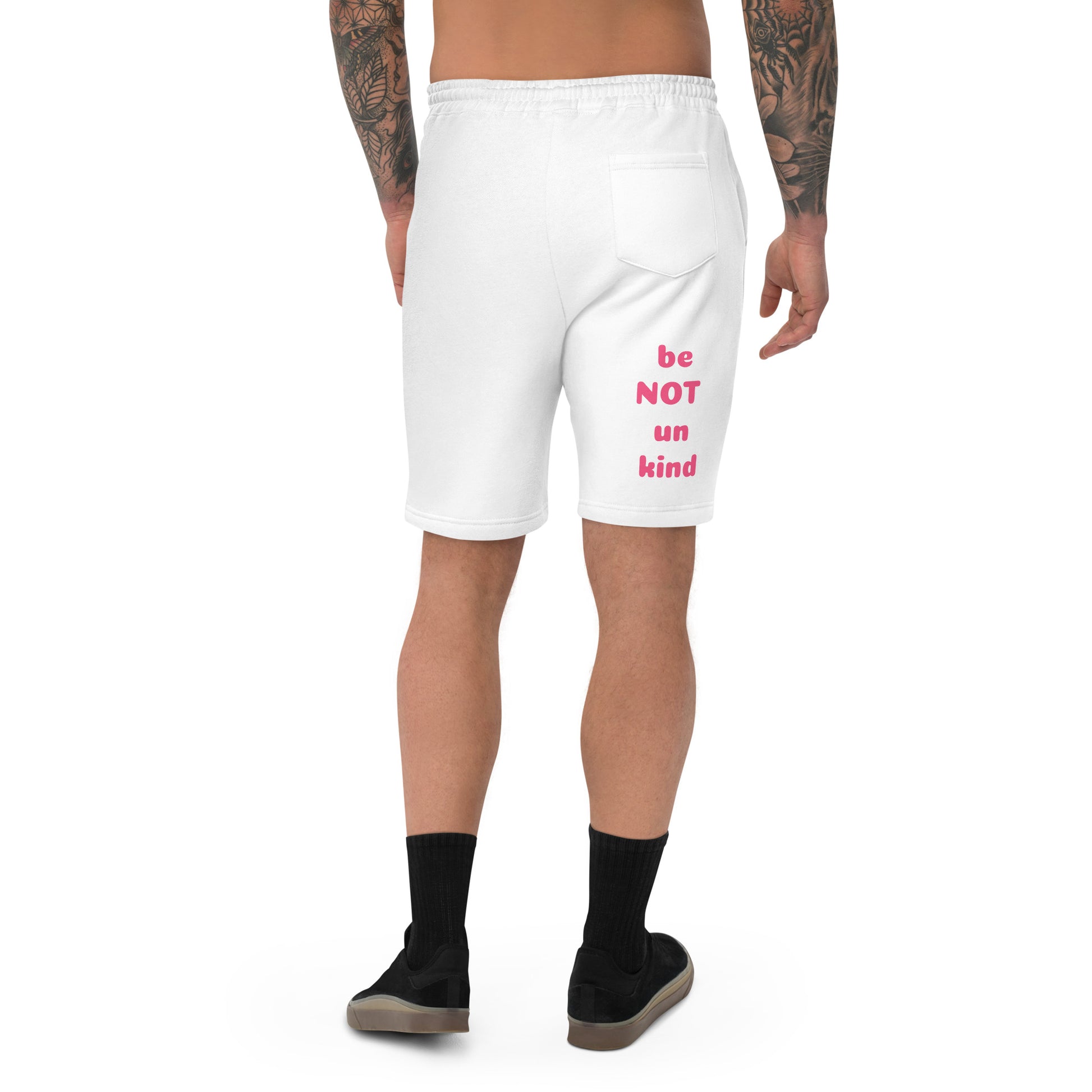 White shorts with pink text worn by a person on a white background