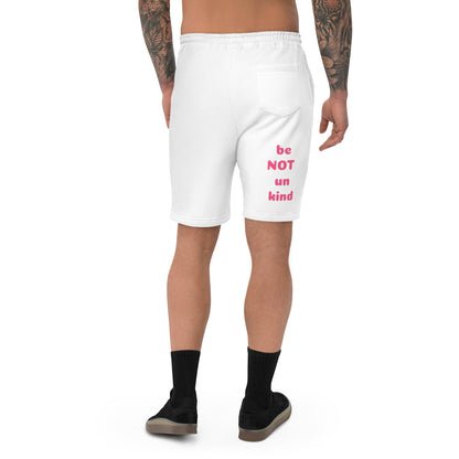 White shorts with pink text worn by a person on a white background