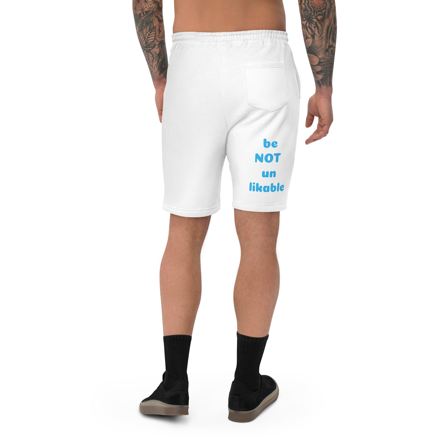 White shorts with text 'be NOT un likable' worn by a person on a white background