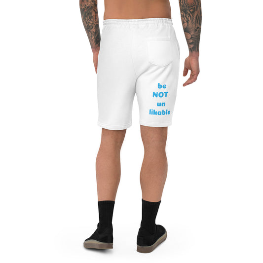 White shorts with text 'be NOT un likable' worn by a person on a white background