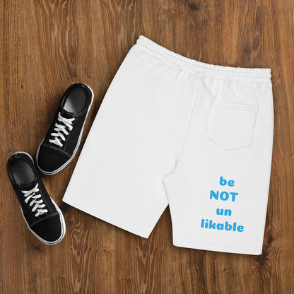 White shorts with text and black sneakers on a wooden surface