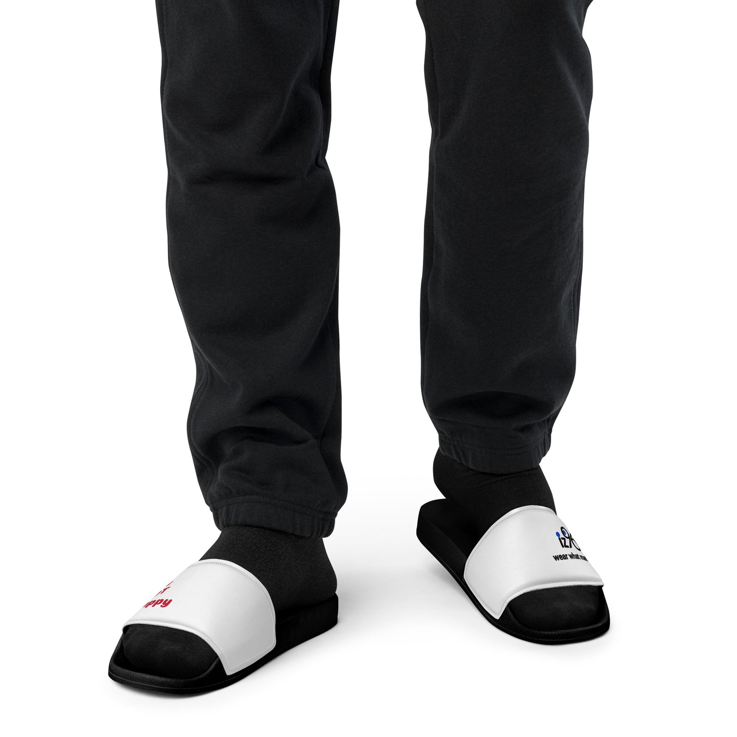 Black and white slippers with a text and logo design worn by a person in black pants on a white background