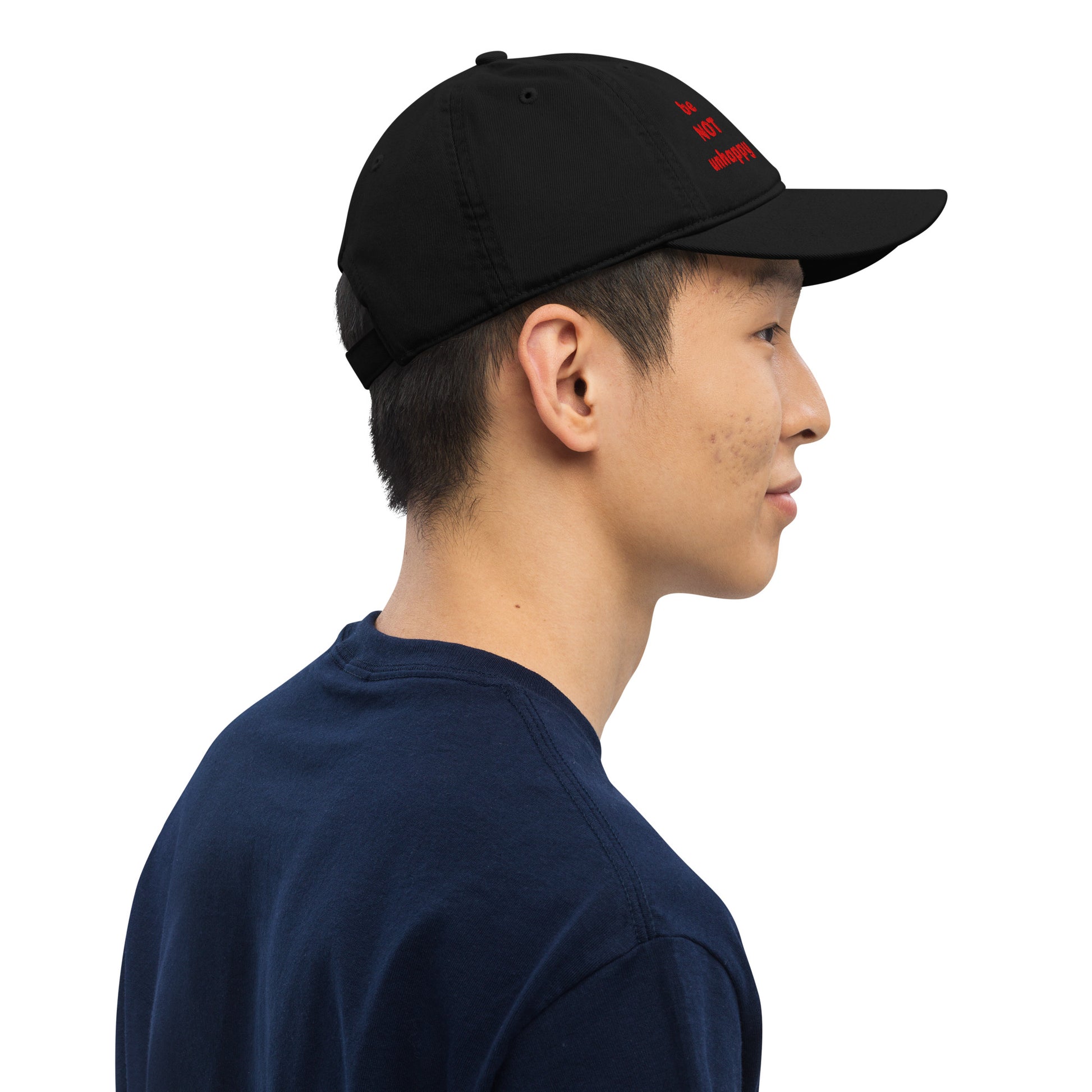 Person wearing a black cap and navy shirt on a white background