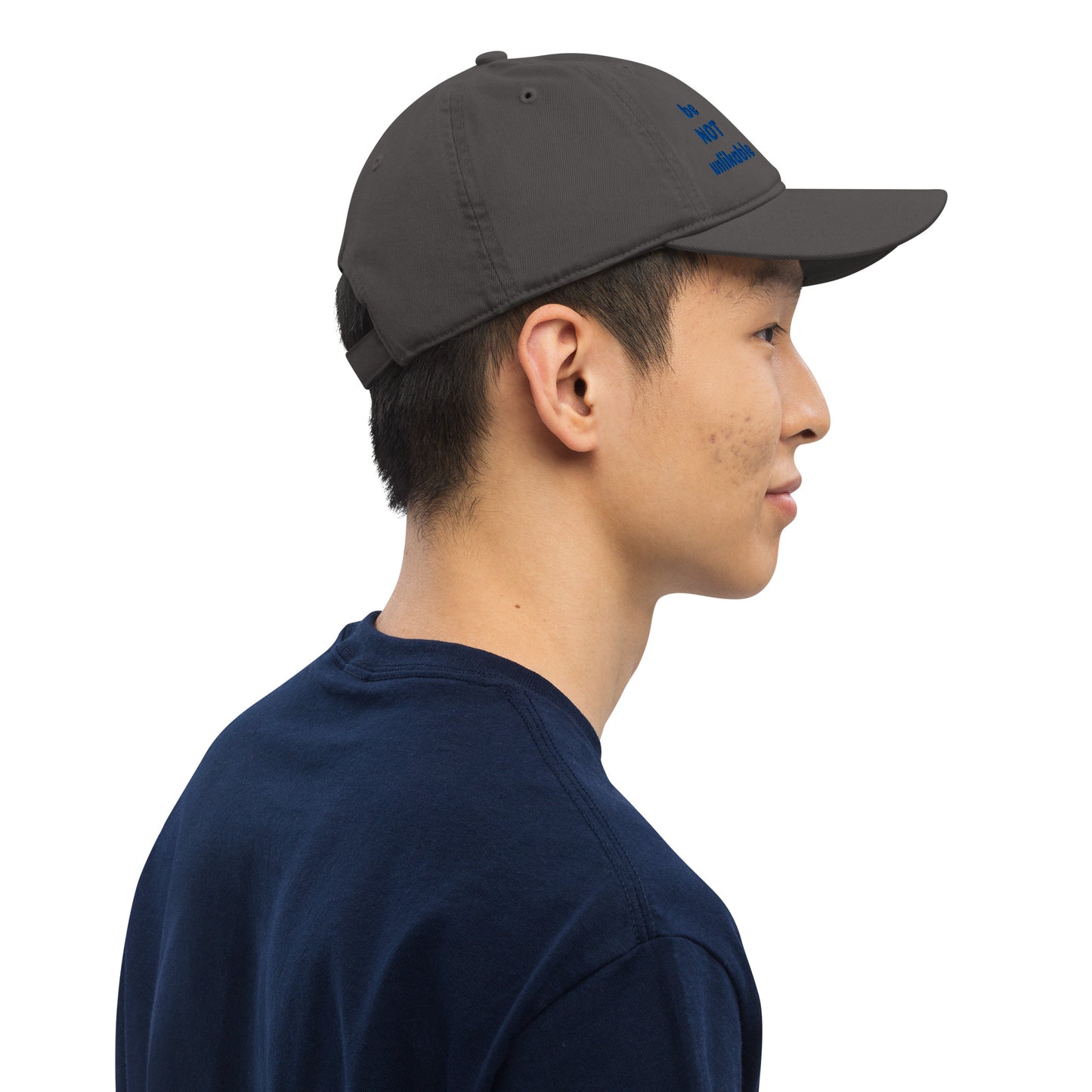 Person wearing a dark gray cap and navy shirt on a white background