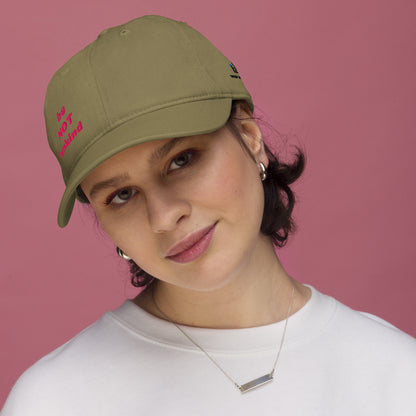 Woman wearing a green cap with text on a pink background