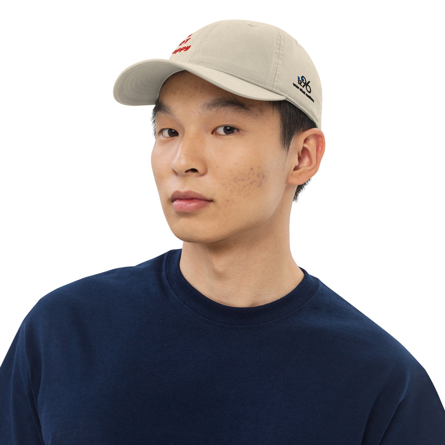 Person wearing a beige cap and navy shirt on a white background