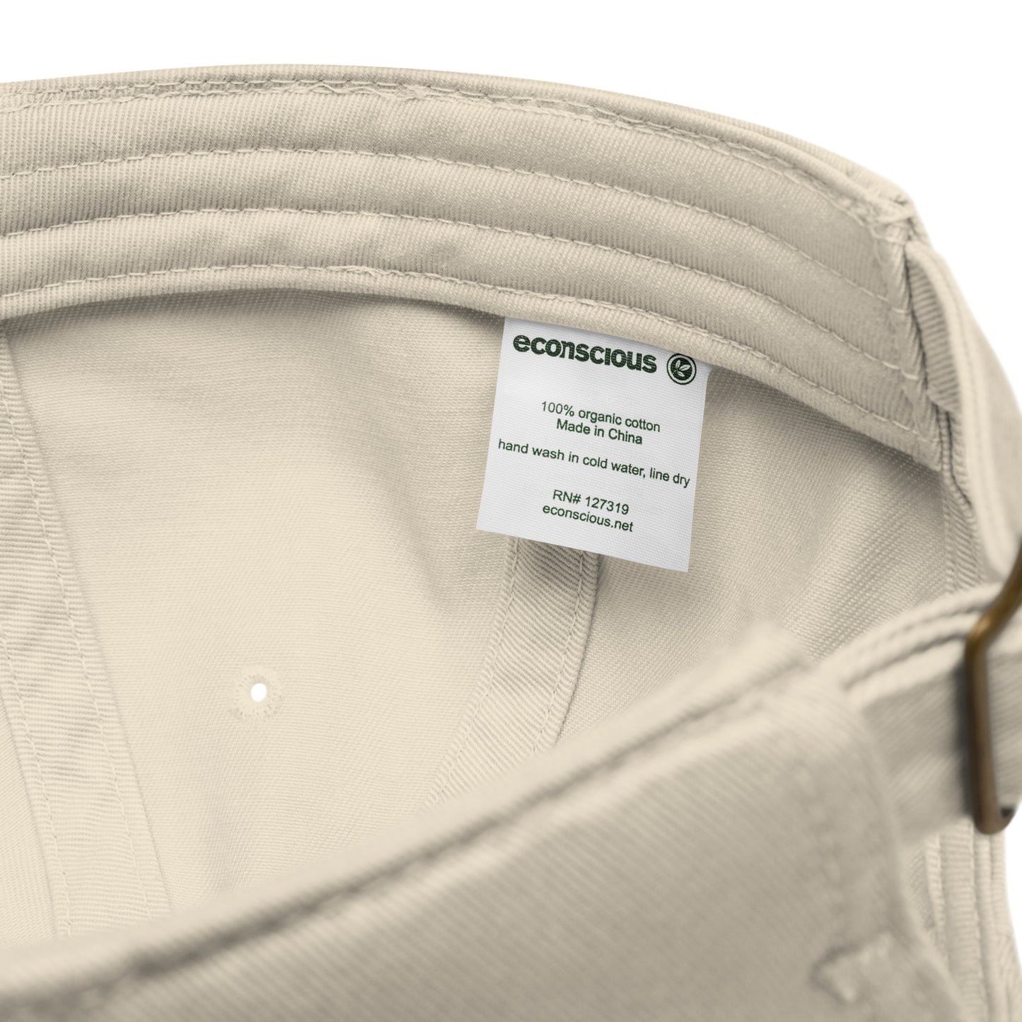 Close-up of a beige hat with a label on a white background