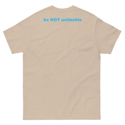 sand t-shirt with 'be NOT unlikable' text on the back against a white background
