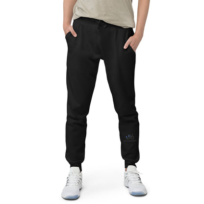 Person wearing black jogger pants with a brand logo on a white background