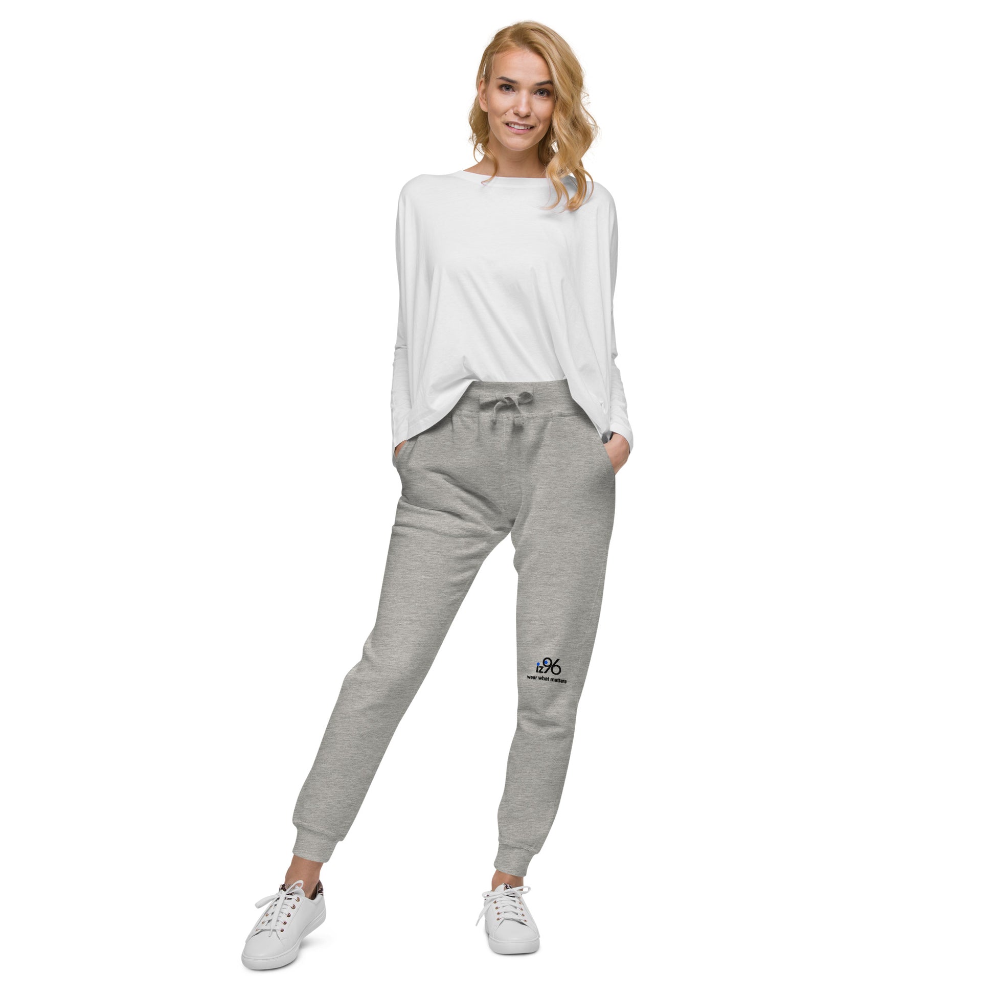 Woman wearing a white long-sleeve top and gray sweatpants on a white background