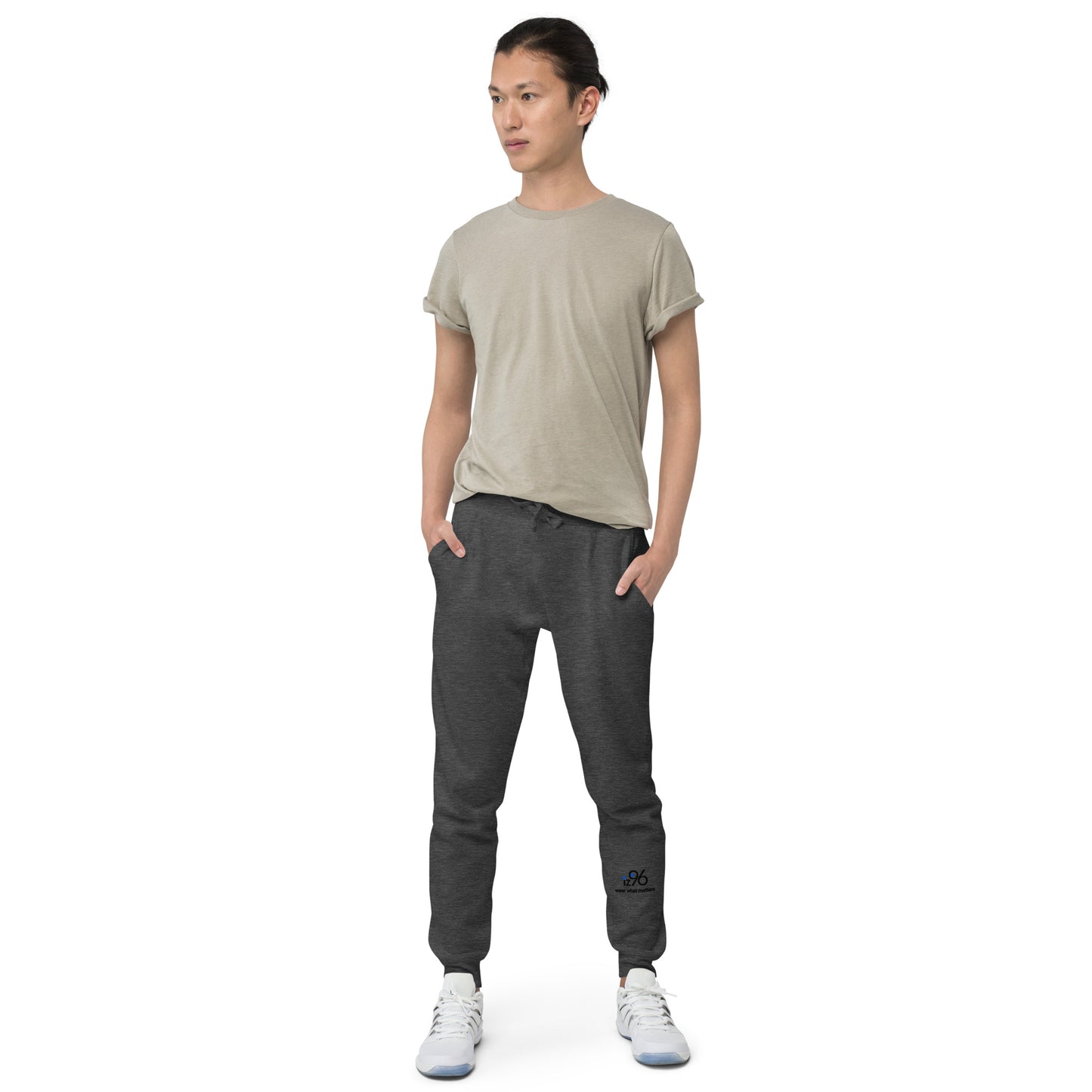Person wearing a beige t-shirt and charcoal gray jogger pants on a white background