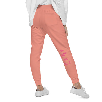 Person back view wearing rose pink sweatpants and white sneakers on a white background
