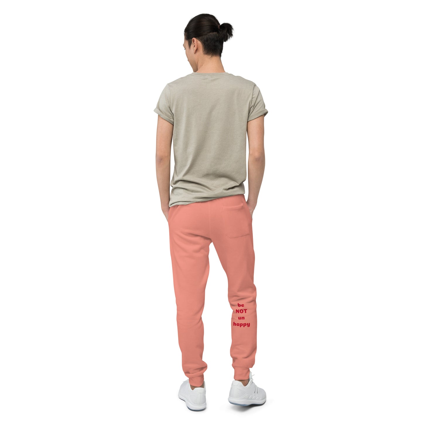 Person wearing a beige t-shirt and rose pants on a white background