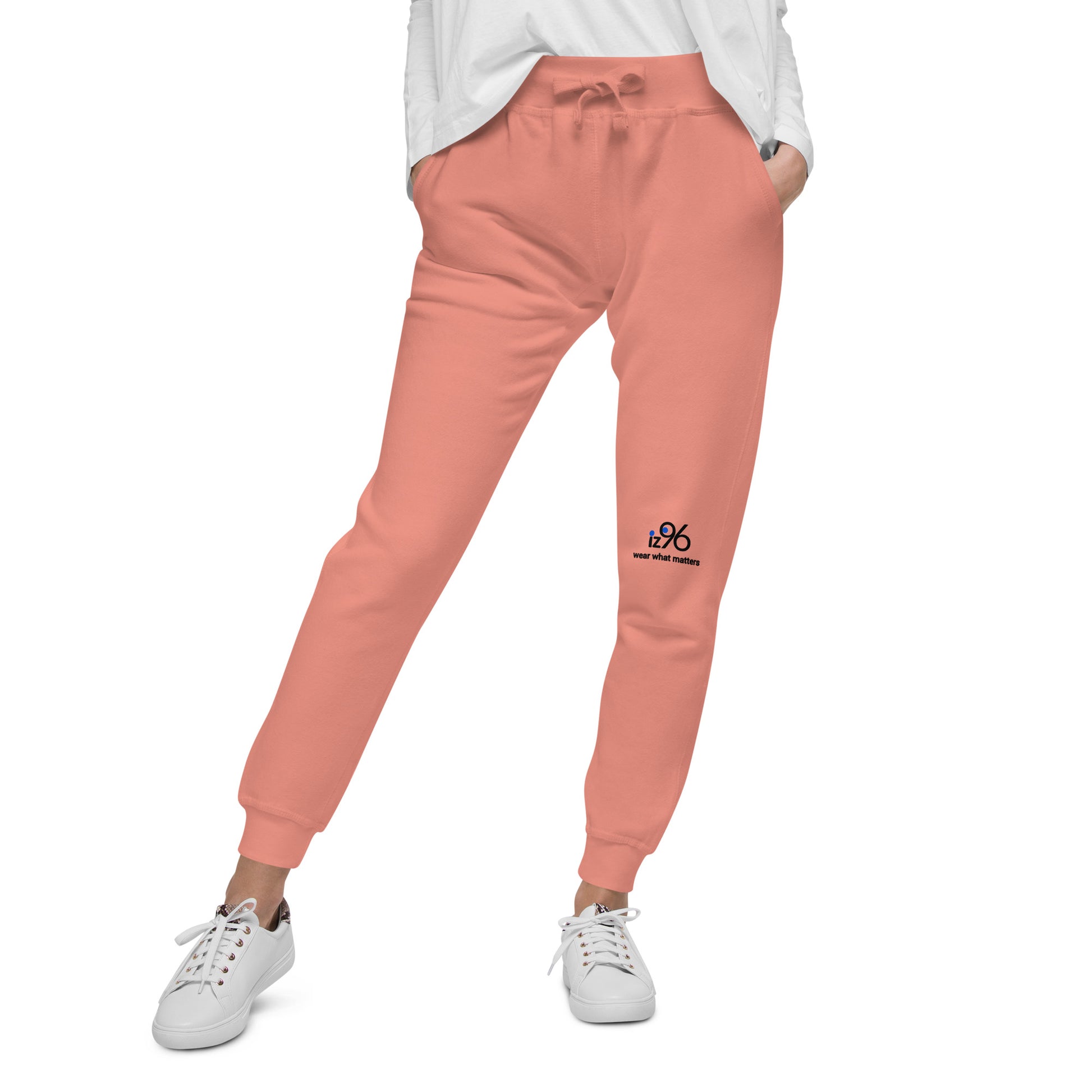 Person wearing rose pink sweatpants and white sneakers on a white background