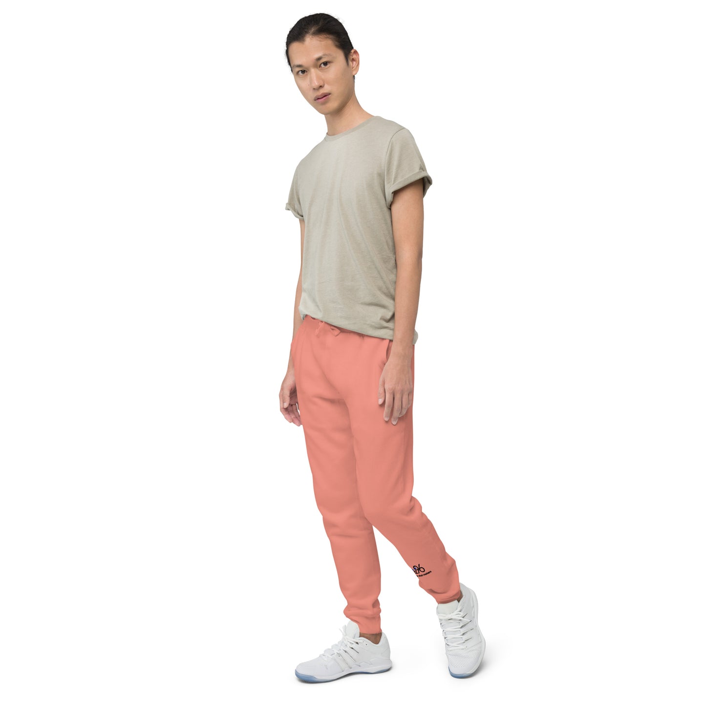 Person wearing a beige t-shirt and rose pink pants on a white background