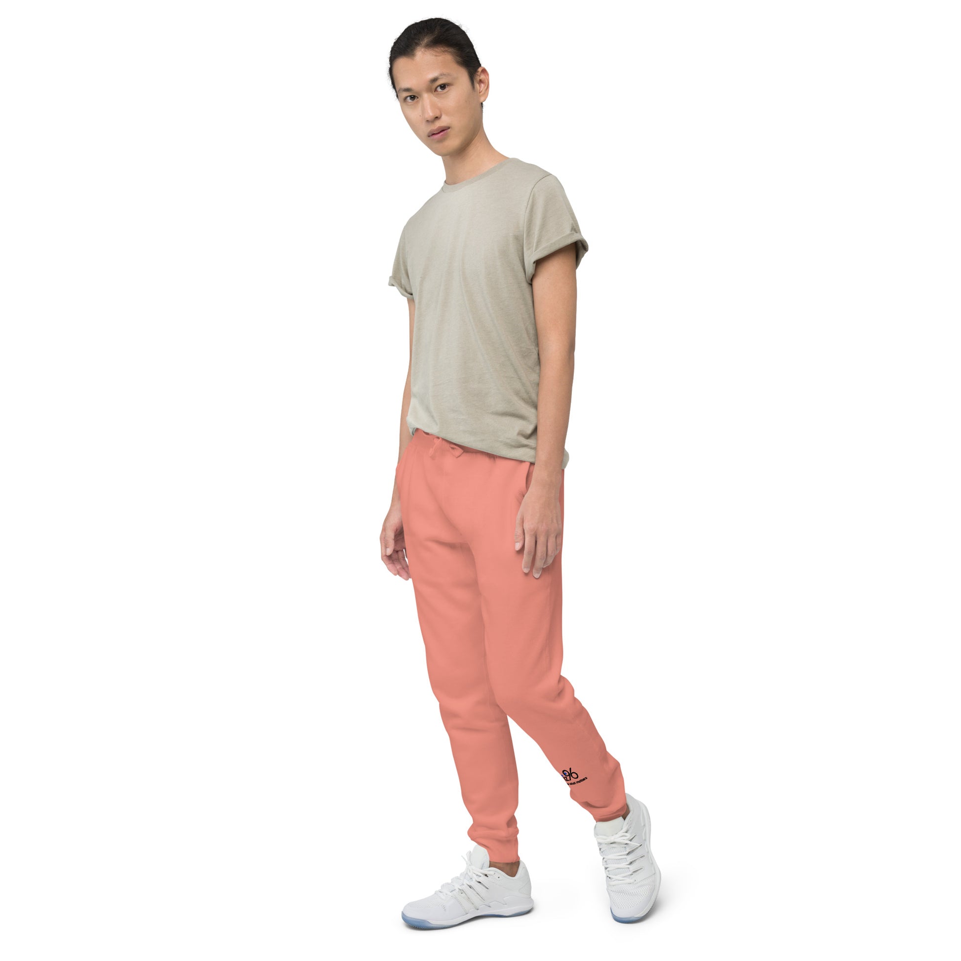 Person wearing a beige t-shirt and rose pink pants on a white background