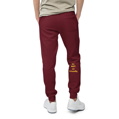 Maroon sweatpants with yellow text worn by a person on a white background