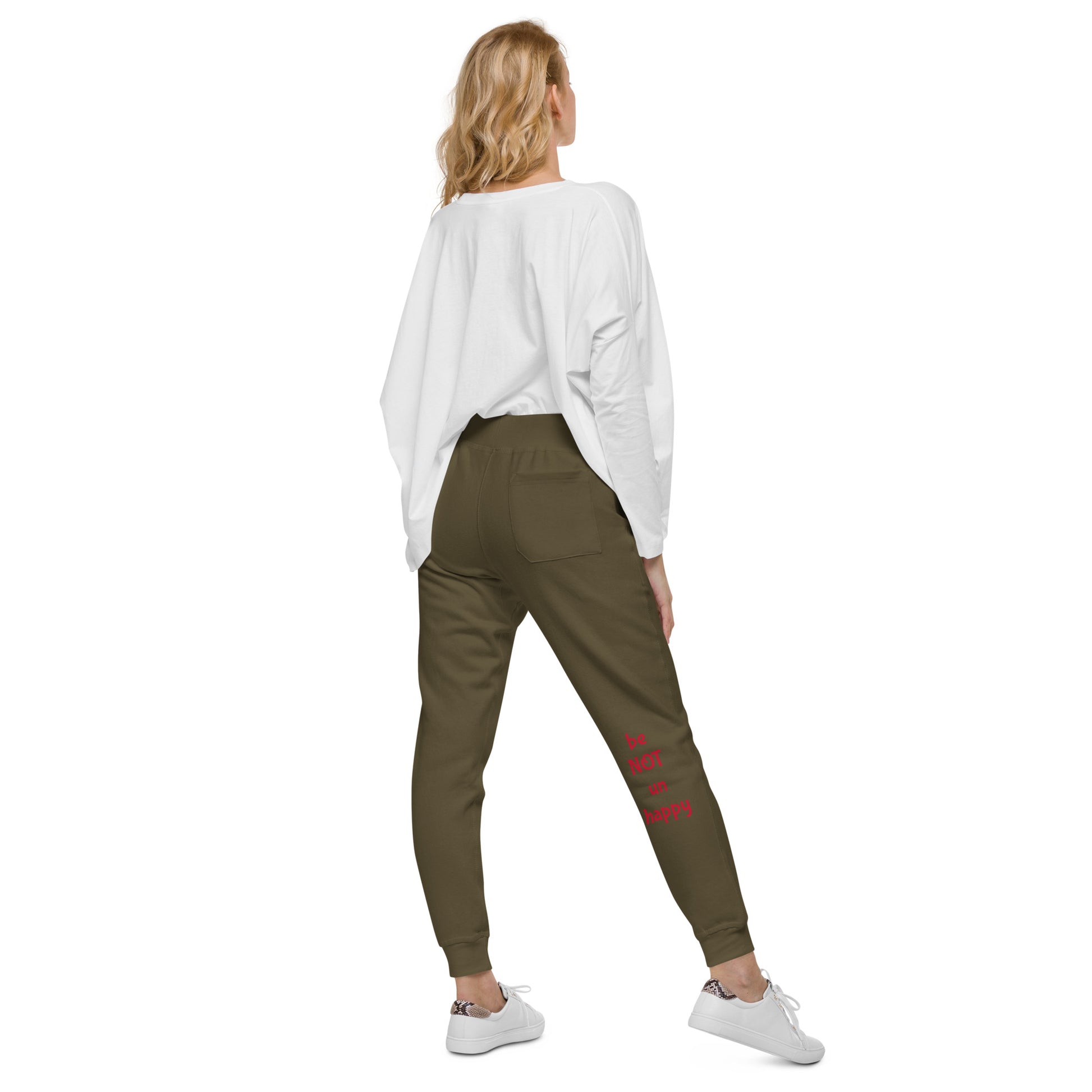Woman wearing olive green pants and a white top on a white background