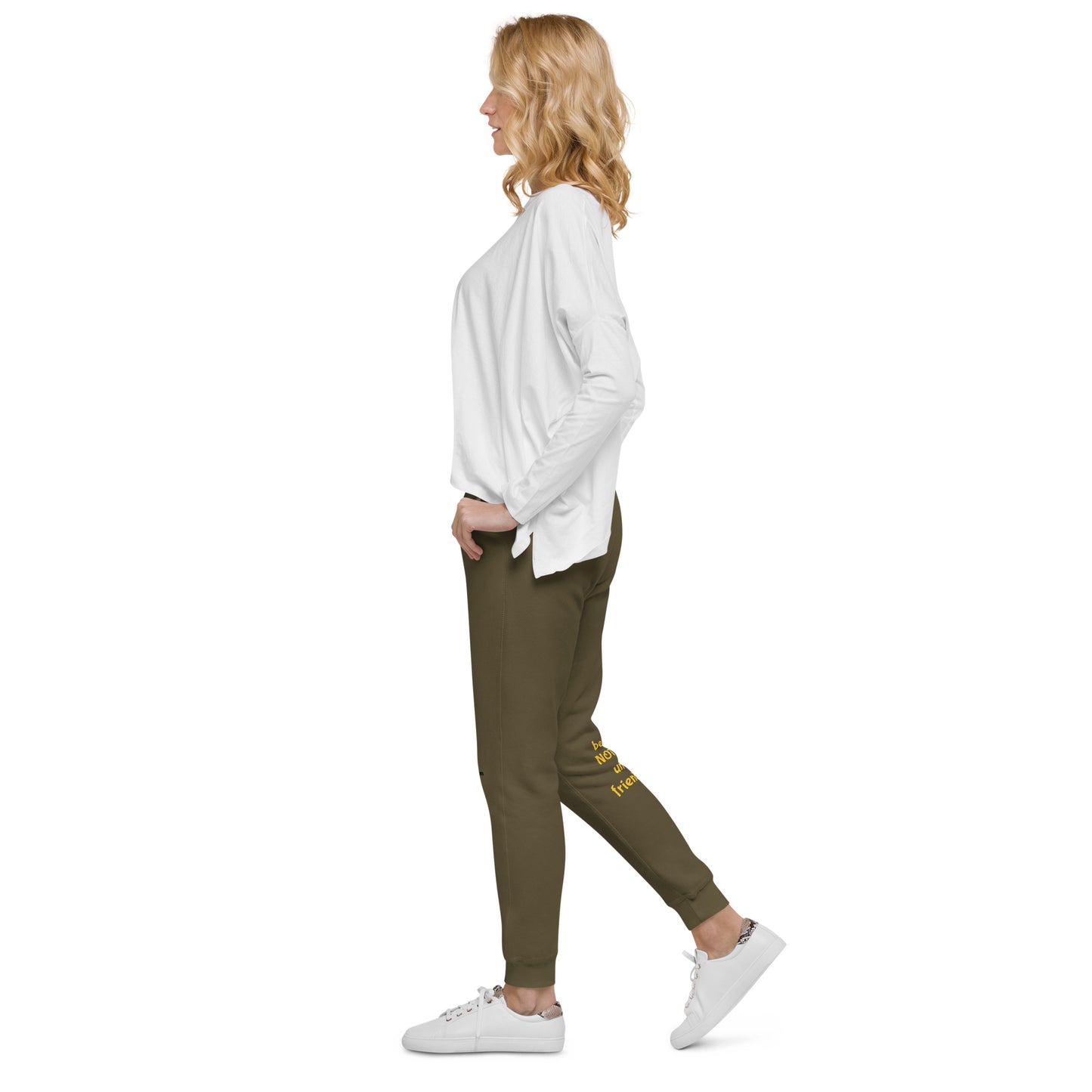 Woman wearing a white shirt and green jogger pants on a white background